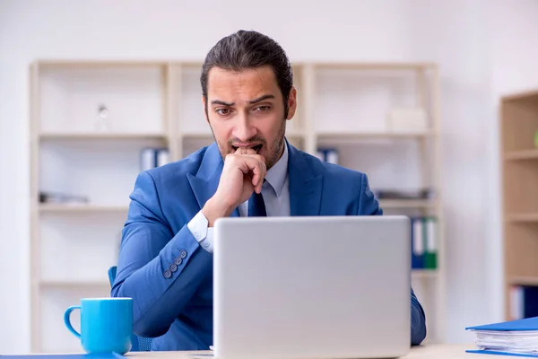 Jonge mannelijke werknemer die op de werkplek werkt — Stockfoto