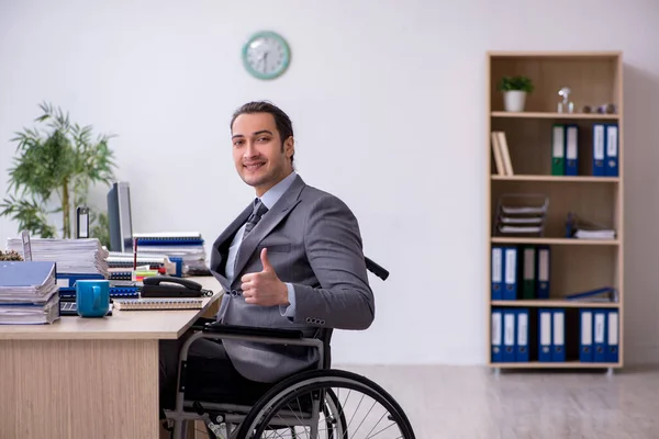 Junge männliche Auszubildende im Rollstuhl am Arbeitsplatz — Stockfoto