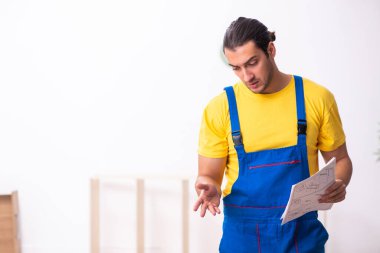 Genç erkek marangoz içeride çalışıyor.