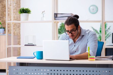 Ofiste çalışan genç bir erkek.