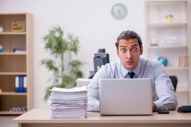 Genç erkek çalışan ofiste oturuyor.