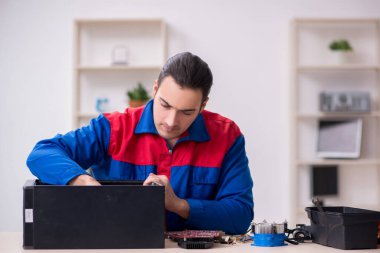Bilgisayar tamir eden genç bir erkek tamirci.