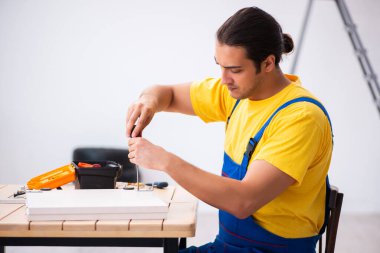 Genç erkek marangoz içeride çalışıyor.