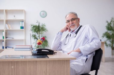 Klinikte çalışan yaşlı bir erkek kardiyolog.