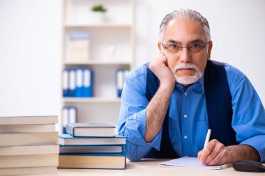 Kitap yazan yaşlı bir erkek yazar.