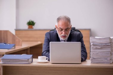 Ofiste çalışan yaşlı bir erkek.