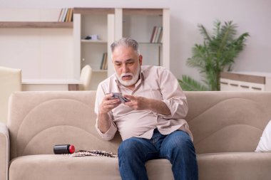 Yaşlı hasta adam evde acı çekiyor.