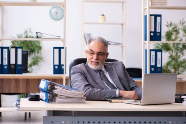 Ofiste çalışan yaşlı bir erkek.