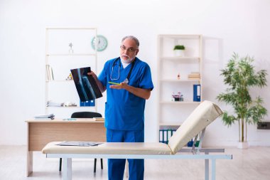 Hastanede çalışan yaşlı doktor radyoloji uzmanı.
