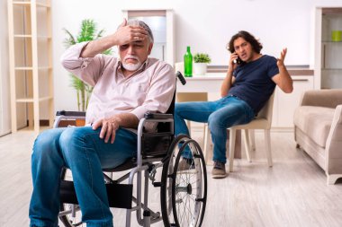 Tekerlekli sandalyedeki yaşlı adam ve genç kötü bakıcı.