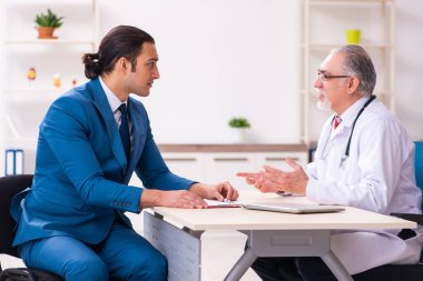 Genç işadamı yaşlı doktorla görüşüyor.