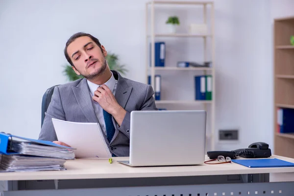 Jovem funcionário masculino infeliz com excesso de trabalho no escritório — Fotografia de Stock