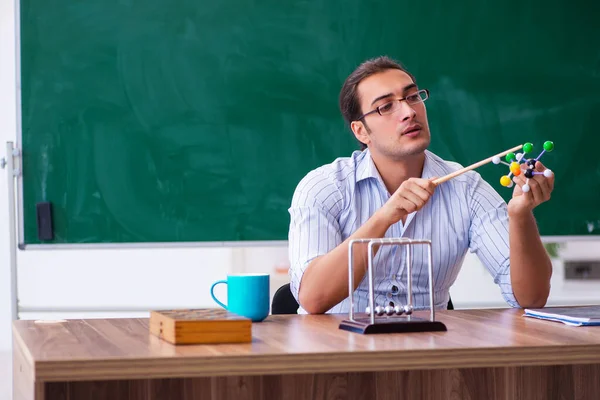 Jonge mannelijke leraar natuurkundige voor schoolbord — Stockfoto
