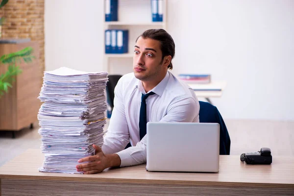 Joven empleado masculino infeliz con el trabajo excesivo — Foto de Stock