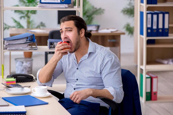 職場で食べ物を待っている空腹の男性従業員 — ストック写真