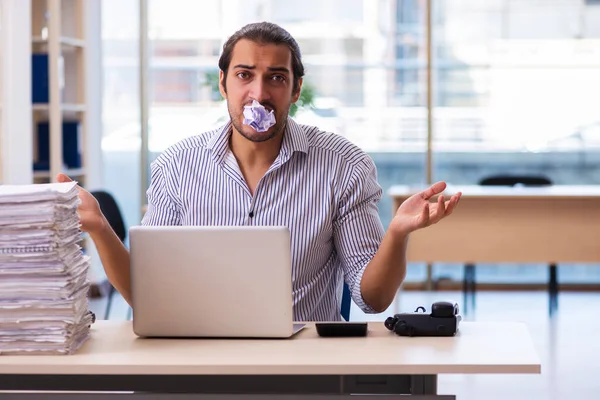 Joven empleado masculino descontento con el trabajo excesivo en la oficina — Foto de Stock