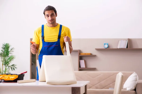 Jonge mannelijke aannemer reparatie stoel thuis — Stockfoto