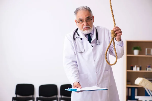 Old male doctor committing suicide at workplace — Stock Photo, Image