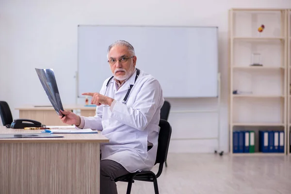 Klinikte çalışan yaşlı bir erkek radyolog. — Stok fotoğraf