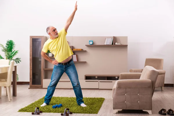 Hombre anciano haciendo ejercicios deportivos en casa — Foto de Stock