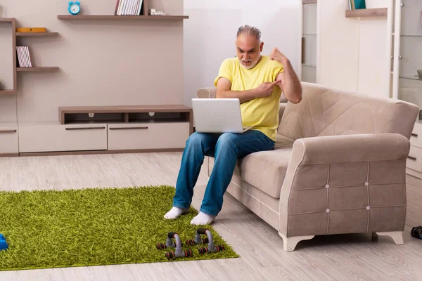 Homem idoso fazendo exercícios esportivos em casa — Fotografia de Stock