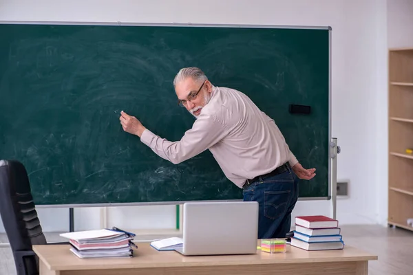 Gammal manlig lärare sitter i klassrummet — Stockfoto