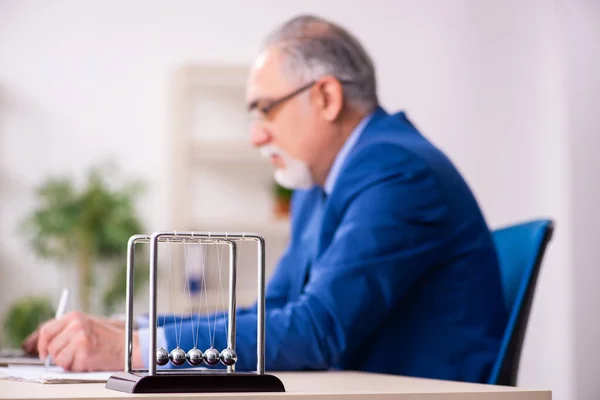 Homem velho empregado homem de negócios e bolas de meditação na mesa — Fotografia de Stock