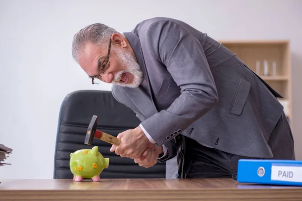 Velho empregado masculino segurando martelo no conceito de planejamento orçamentário — Fotografia de Stock