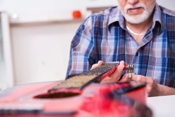 Старший мастер по ремонту музыкальных инструментов дома — стоковое фото