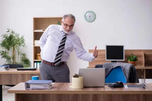 Vecchio dipendente maschio affetto da radicolite sul posto di lavoro — Foto Stock