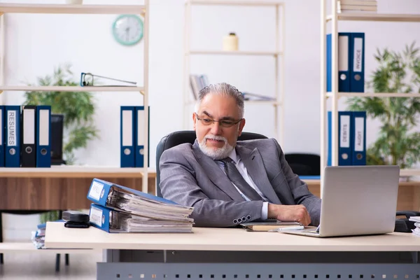 Stary męski pracownik pracujący w biurze — Zdjęcie stockowe
