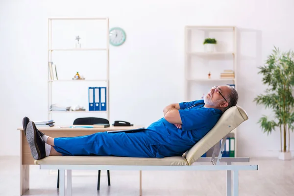 Old male doctor extremely tired after night shift — Stock Photo, Image