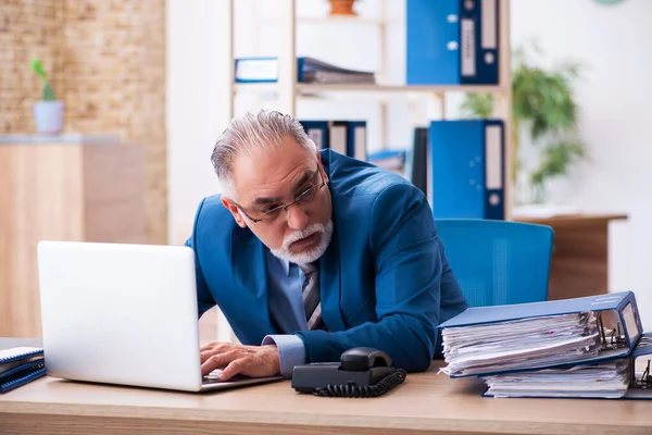 Vecchio contabile maschio infelice con il lavoro eccessivo sul posto di lavoro — Foto Stock