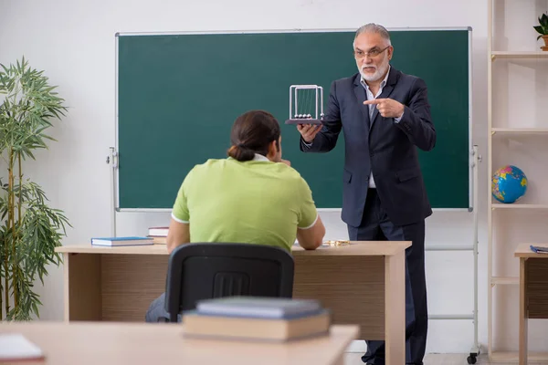 教室で高齢の物理の先生と男性学生 — ストック写真