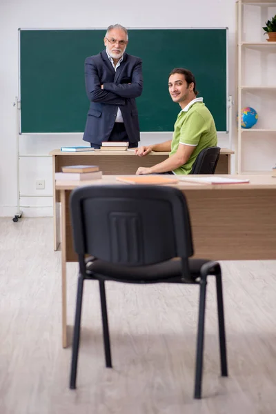 Leeftijd leraar en mannelijke student in de klas — Stockfoto