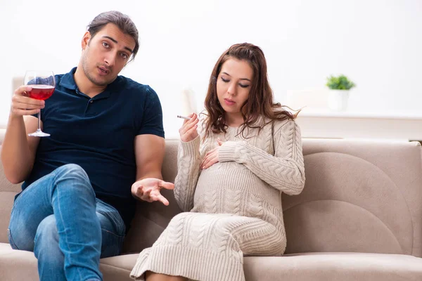 Homem e mulher grávida em hábitos nocivos conceito — Fotografia de Stock