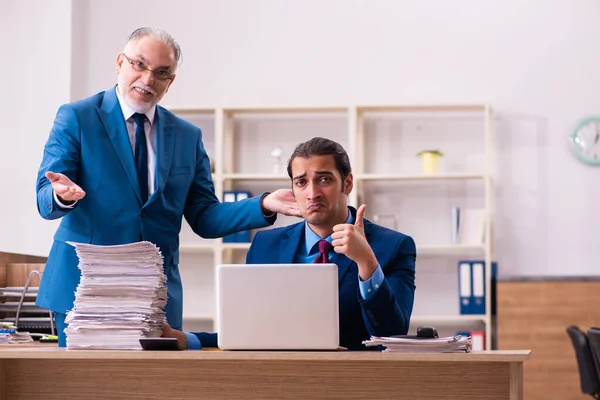 Oude mannelijke baas en zijn jonge mannelijke assistent in pesten concept — Stockfoto