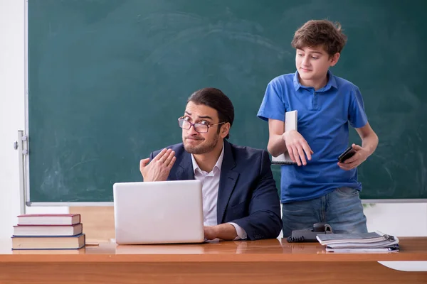 Jonge mannelijke leraar en schooljongen in de klas — Stockfoto