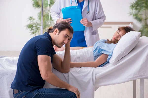 Молодий чоловік відвідує хвору дружину в клініці — стокове фото