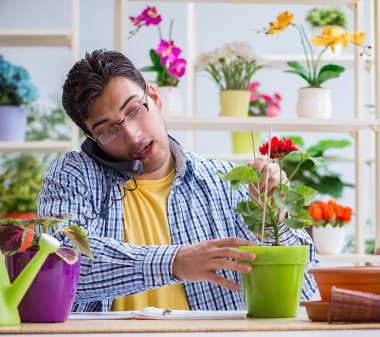 Çiçekçide çalışan genç bir adam.