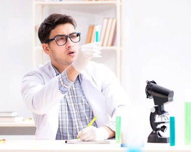 Kimya öğrencisi sınıfta kimyasal deneyler yapıyor.