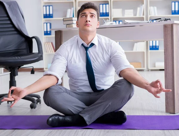 Man meditating in the office to cope with stress — Stock Photo, Image