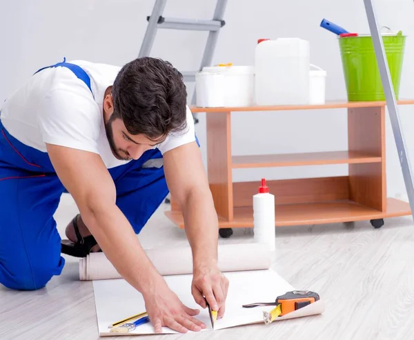 Reparatör gör renovering reparation i huset med papper wallpa — Stockfoto