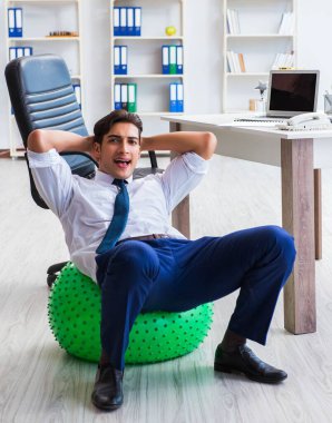 Genç işadamı iş yerinde spor yapıyor.