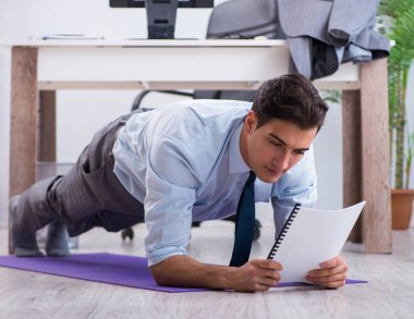 İş adamı tatilde ofiste spor yapıyor.