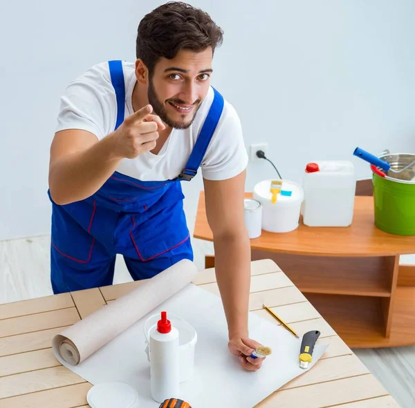 Trabajador trabajando en el papel pintado durante la renovación —  Fotos de Stock