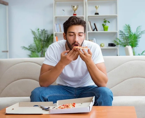 Man eten pizza met een afhaalmaaltijd thuis ontspannen rusten — Stockfoto