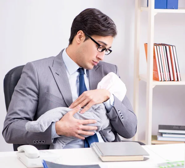 Ofiste yeni doğan bebeğe bakan bir iş adamı. — Stok fotoğraf