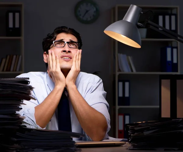 Joven hombre de negocios trabajando horas extras hasta tarde en el cargo —  Fotos de Stock