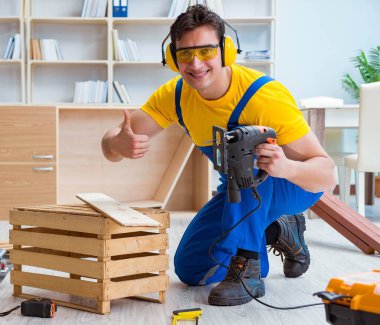 Tamirci marangoz bir seçimle tahta tahtayı kesiyor.